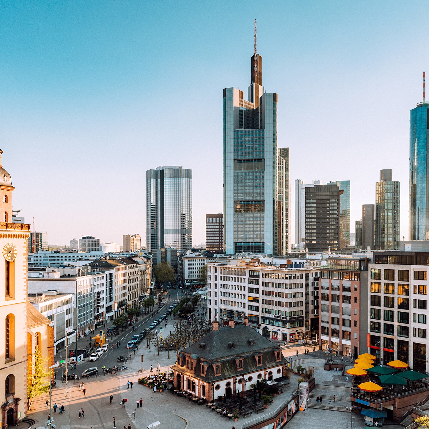 Mix of historic and modern architecture in Frankfurt with skyscrapers and a church tower.