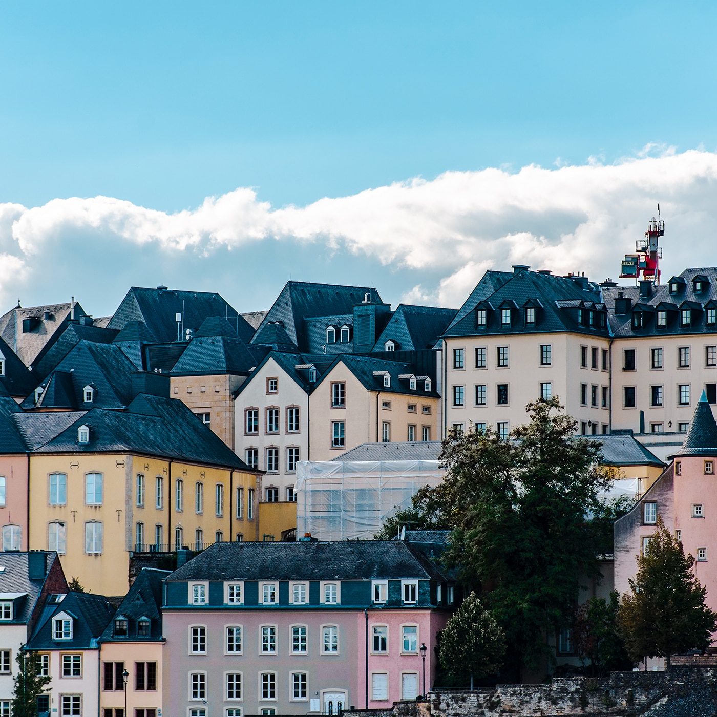 Cluster of traditional pastel buildings with steep roofs in Luxembourg’s historic city center.