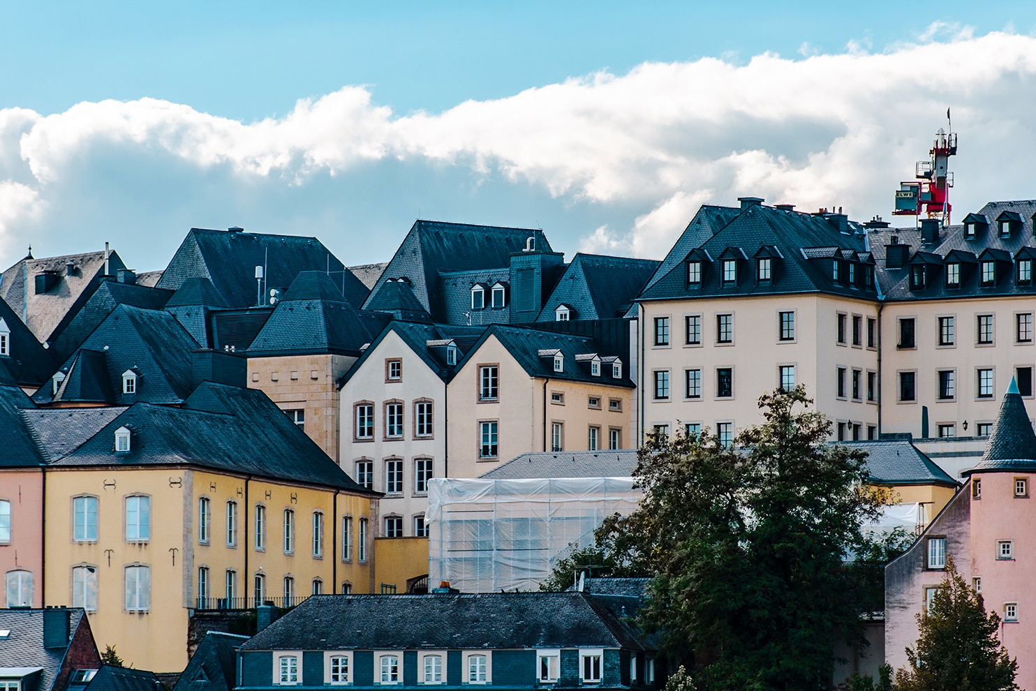 Cluster of traditional pastel buildings with steep roofs in Luxembourg’s historic city center.