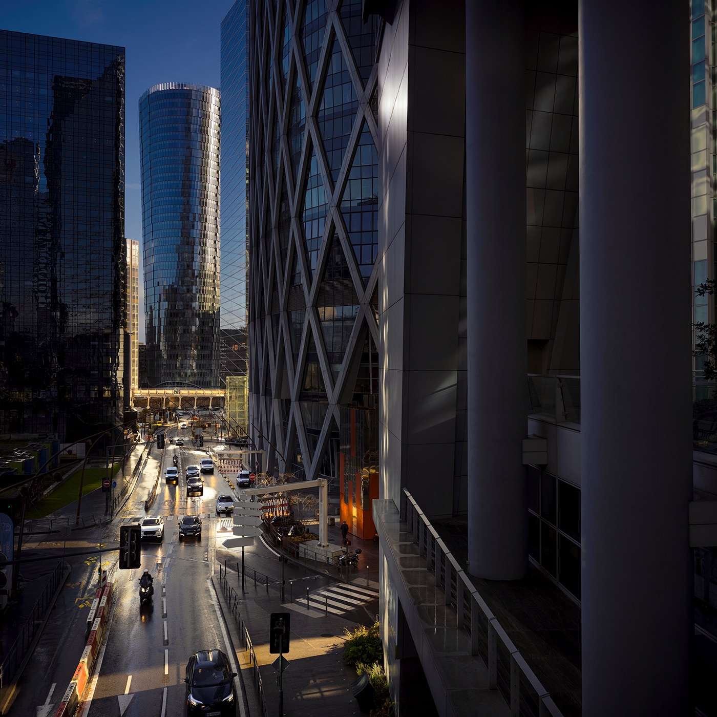 Modern office towers and busy street scene in the La Défense business district of Paris.