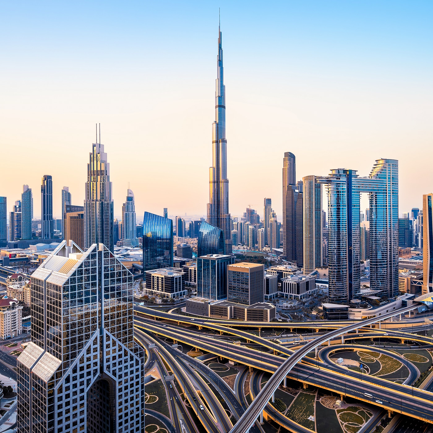 Modern skyline of Dubai with the Burj Khalifa towering above highways and skyscrapers.