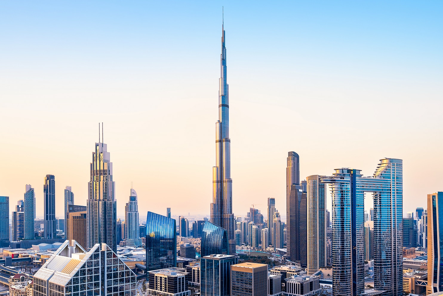 Modern skyline of Dubai with the Burj Khalifa towering above highways and skyscrapers.