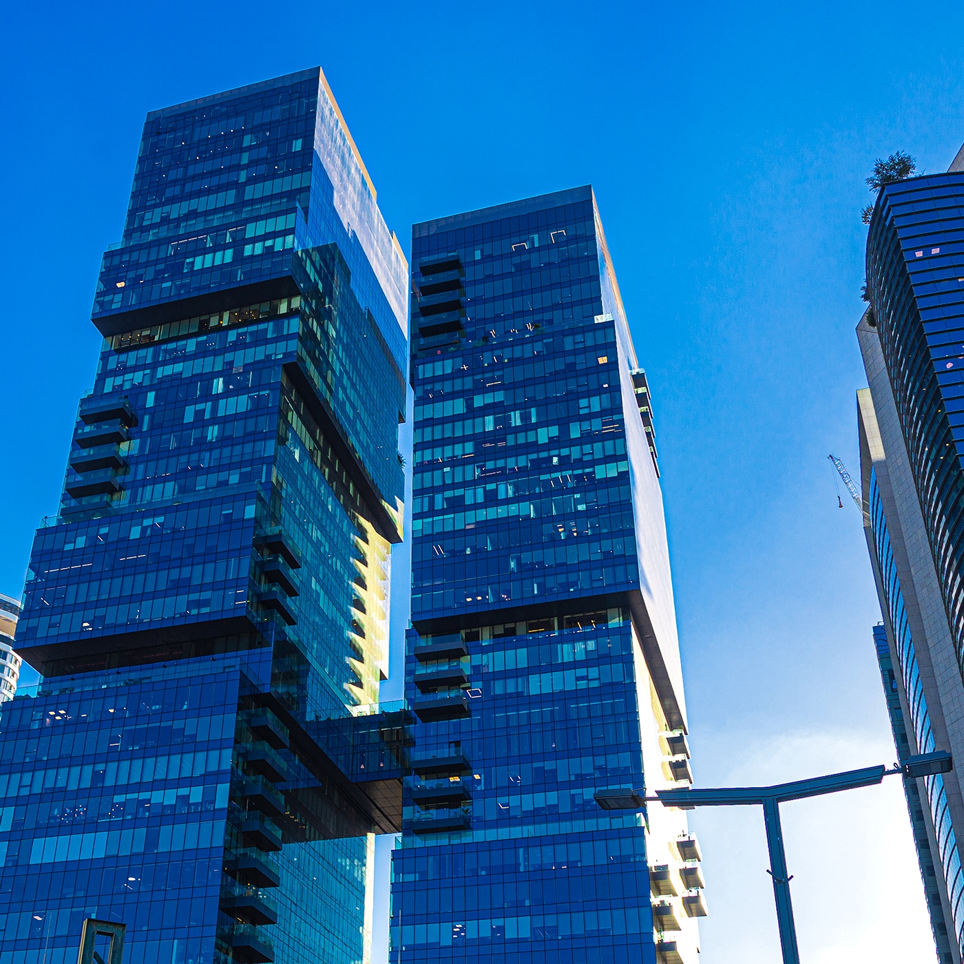 Cluster of modern blue-glass skyscrapers under a clear sky in Tel Aviv’s business district.