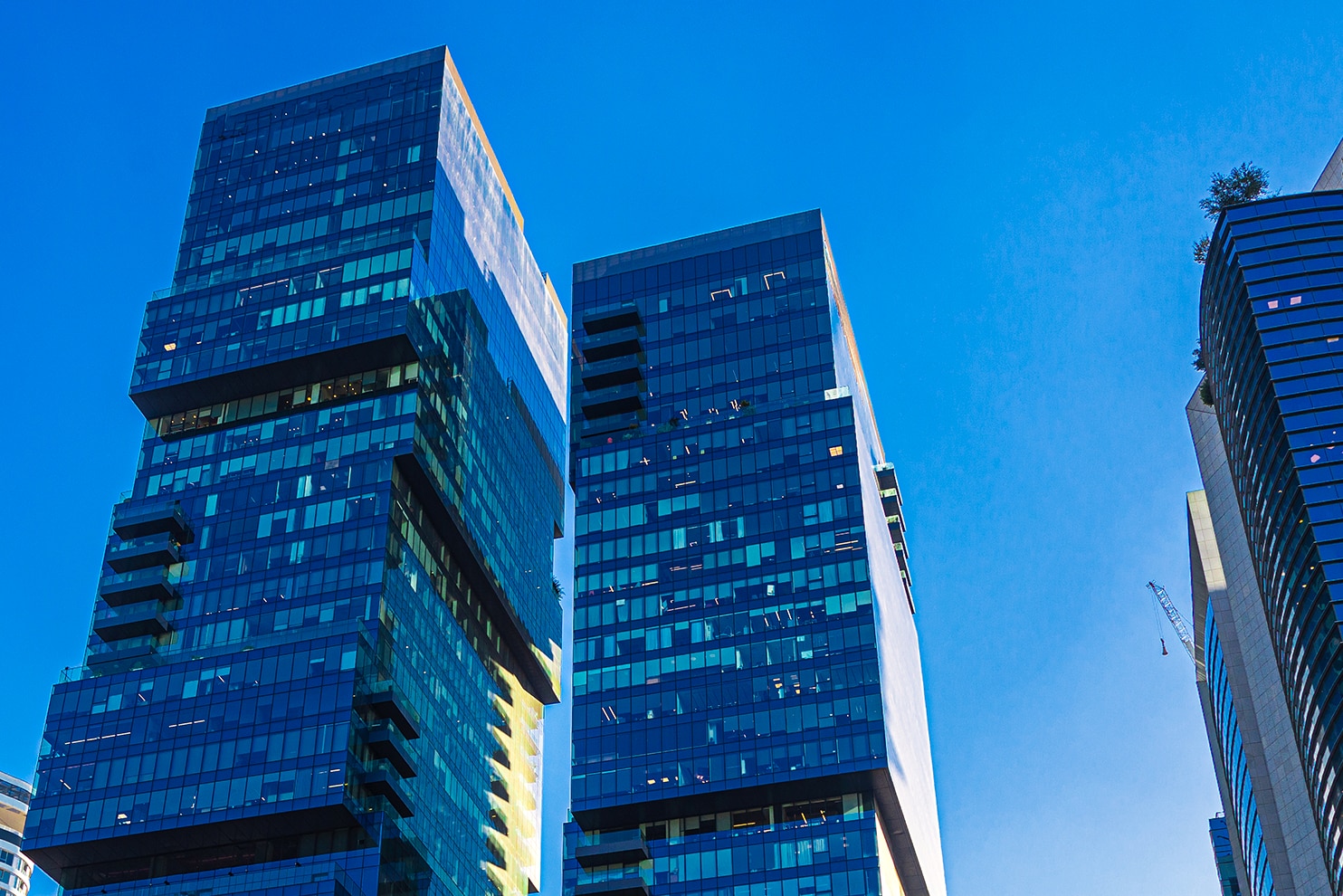 Cluster of modern blue-glass skyscrapers under a clear sky in Tel Aviv’s business district.