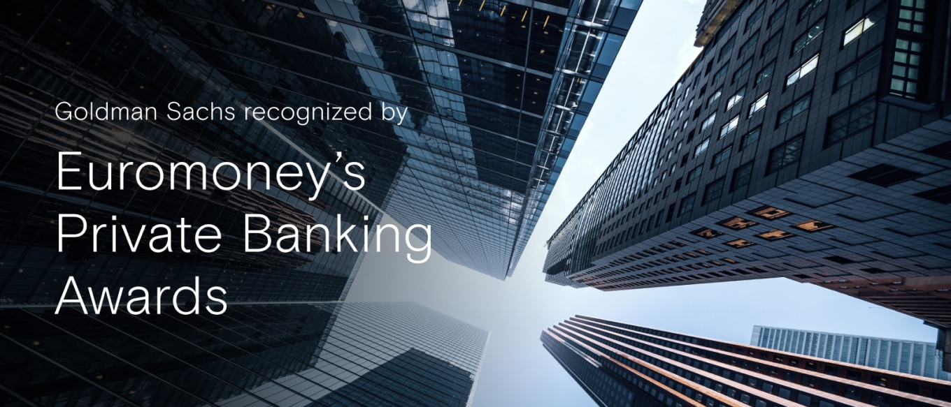 A dramatic low-angle view of modern skyscrapers with reflective glass facades converging towards the sky. Overlaid text reads, "Goldman Sachs recognized by Euromoney’s Private Banking Awards"
