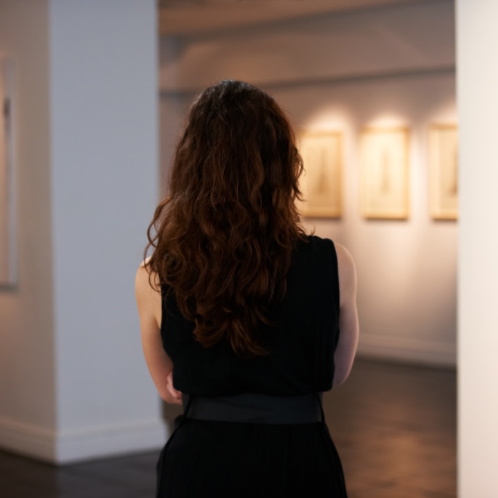 Affluent woman admiring placement of the collectible artwork she once owned.