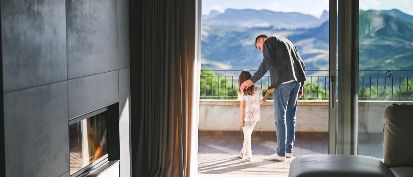 An adult guiding a child through a doorway into a landscape