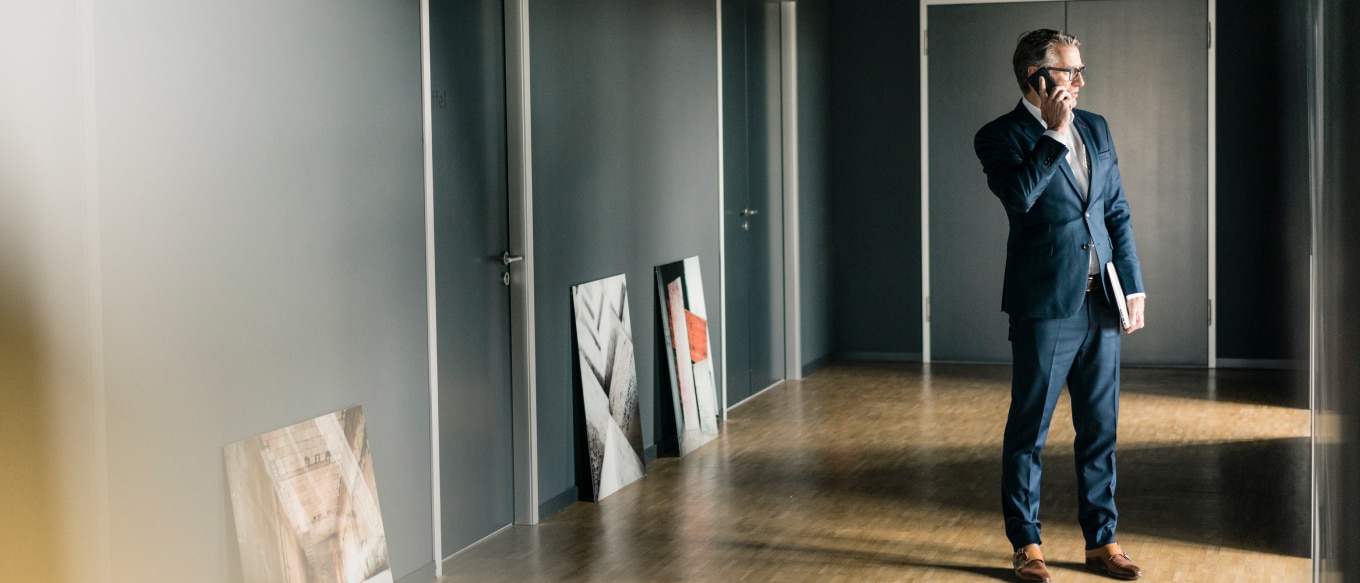 Negotiating the acquisition of art by phone with collectible artwork on floor.