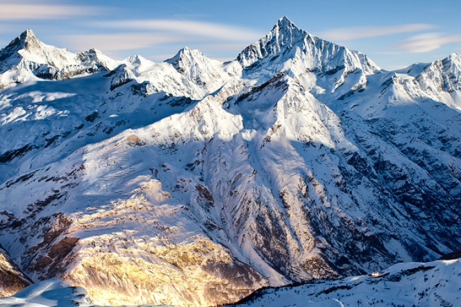A woman in a black outfit looks up at a curved, modern architectural structure with white walls and soft lighting. The perspective emphasizes the building's sweeping design and open space